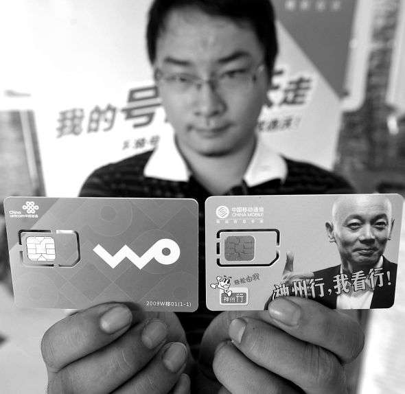 图为海口市民周俊展示通过携号转网业务办理的联通手机卡（左）