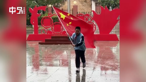 小学生冒雨拾起地上的国旗_风雨中的爱国情怀：陕西渭南小学生冒雨拾起国旗