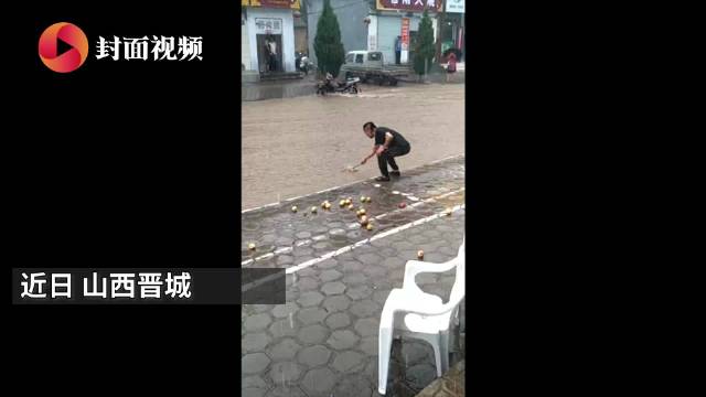 真·水果捞 暴雨中男子用漏勺在门口捞苹果