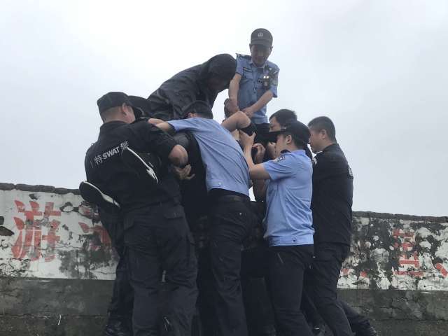 民警用温暖抱抱救回江边醉酒男子_民警和被救男子用矿泉水碰杯，民警用温暖抱抱救回江边醉酒男子