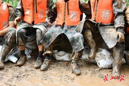 抗洪大堤上武警官兵满身泥泞雨中吃饭_抗洪一线的武警：在雨中进食、累了就躺在堤坝上休息